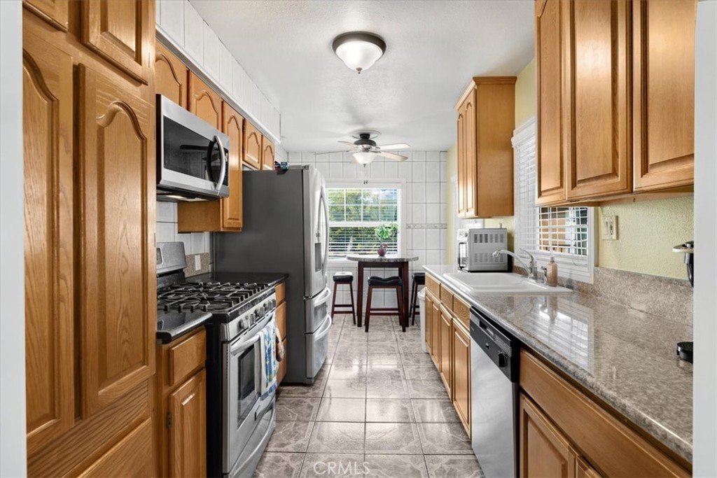 2183 Sinclair Street Pomona, CA 91767 - Photo 24 of 38 a kitchen with stainless steel appliances granite countertop a stove a sink and a refrigerator