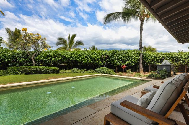a view of a swimming pool with a garden and patio
