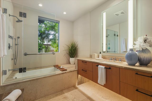 a bathroom with a tub sink and mirror