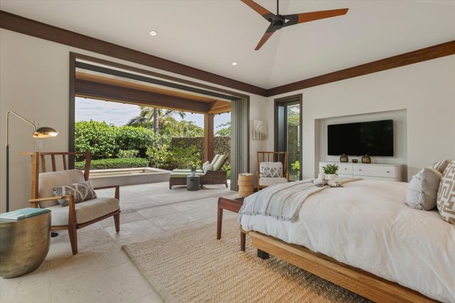 a bedroom with a large bed and a flat tv screen on the dresser