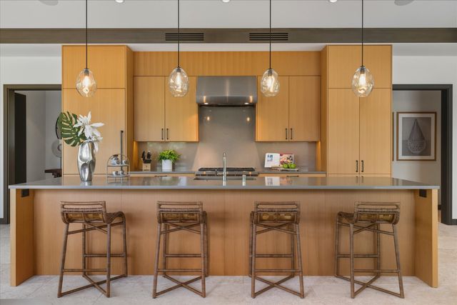 a kitchen with a sink and chairs