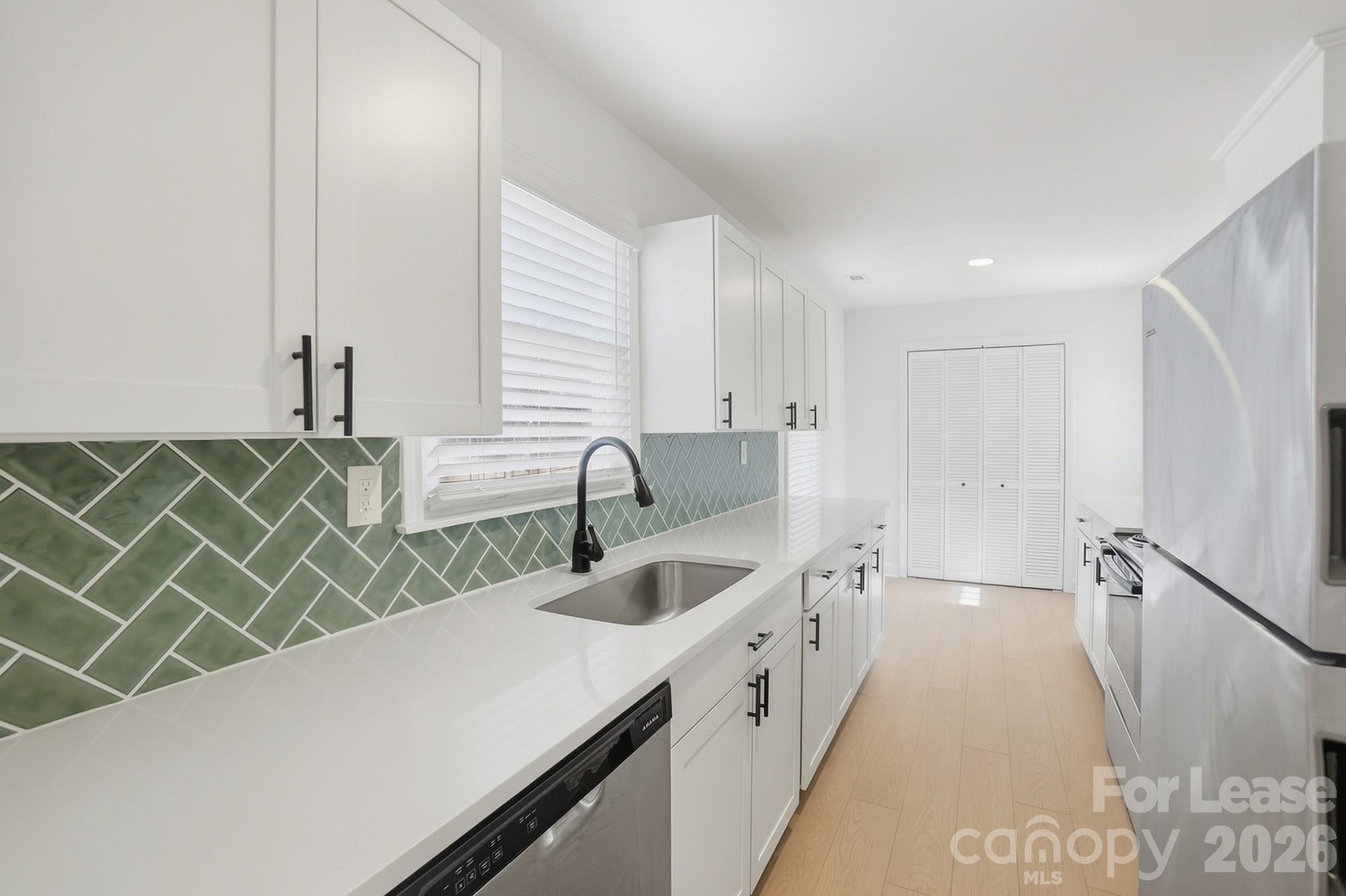318 Hollis Road Charlotte, NC 28209 - Photo 5 of 30 a kitchen with a sink a stove and a wooden cabinets