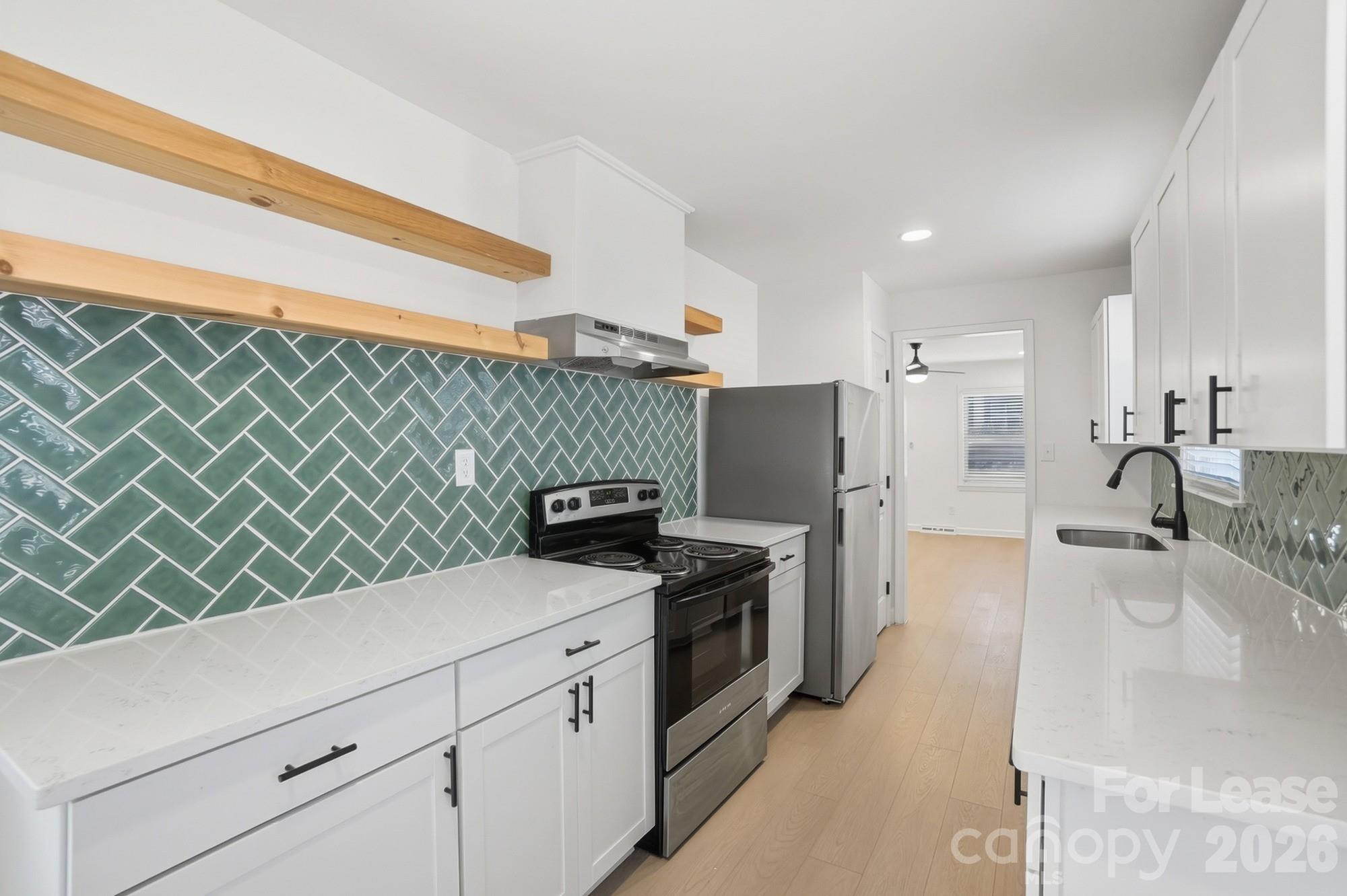 318 Hollis Road Charlotte, NC 28209 - Photo 8 of 30 a kitchen with stainless steel appliances a sink dishwasher stove refrigerator and microwave with wooden floor