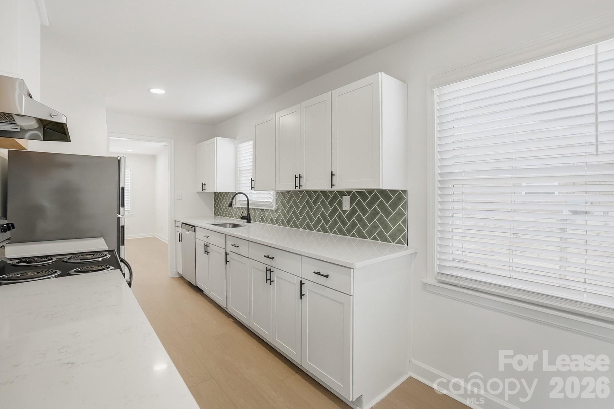 318 Hollis Road Charlotte, NC 28209 - Photo 9 of 30 a kitchen with a sink cabinets and window