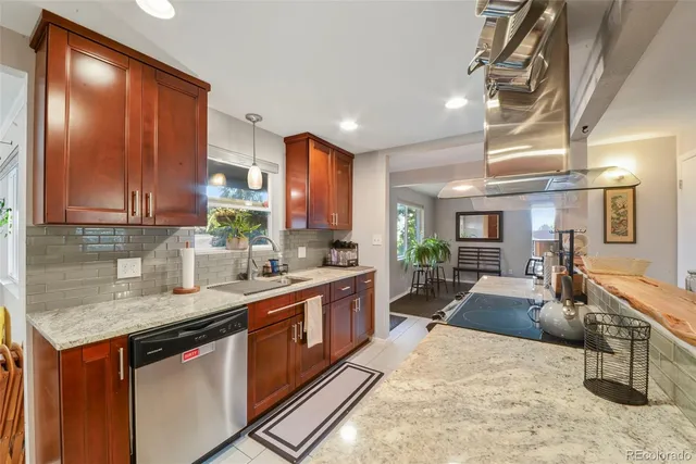 a kitchen with stainless steel appliances granite countertop sink stove and refrigerator