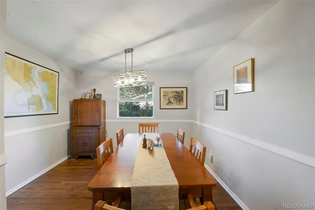 a dining room with furniture a chandelier and wooden floor