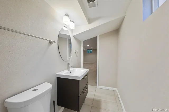 a bathroom with a sink a toilet and mirror