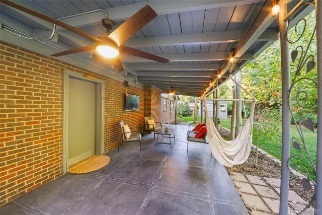 a view of a patio with table and chairs potted plants with floor to ceiling window
