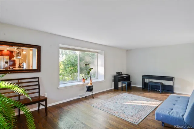 a living room with furniture and a flat screen tv with wooden floor