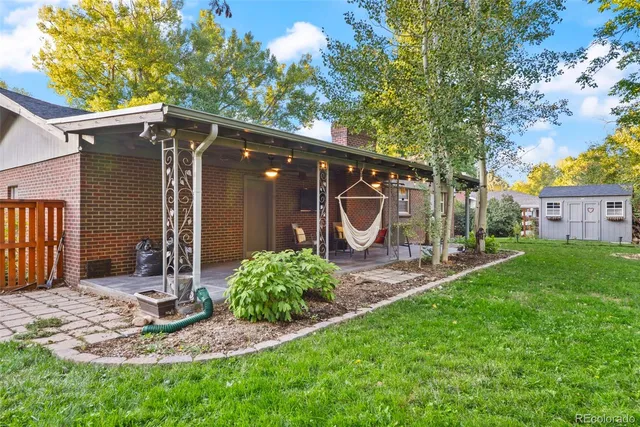 a view of backyard with a table and chairs under an umbrella