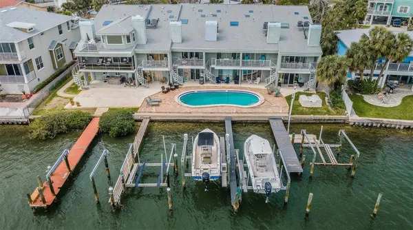 an aerial view of a house with swimming pool and outdoor seating