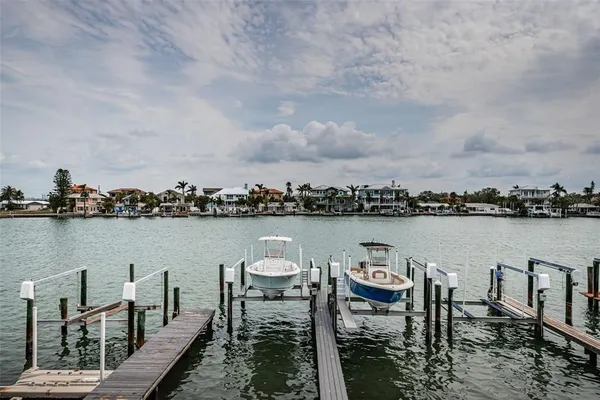 a couple of chairs sitting in a lake next to a lake view