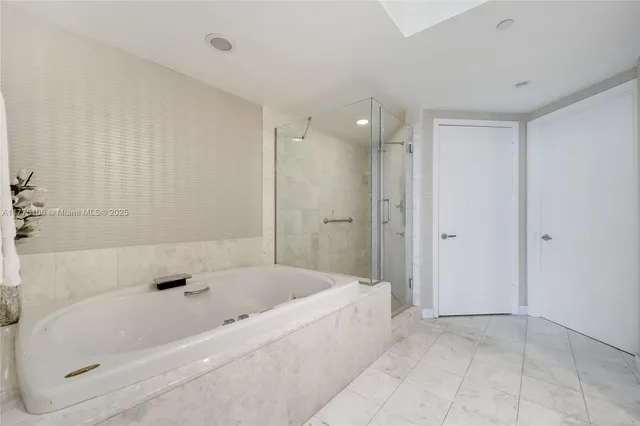 a white bath tub sitting in a bathroom and shower