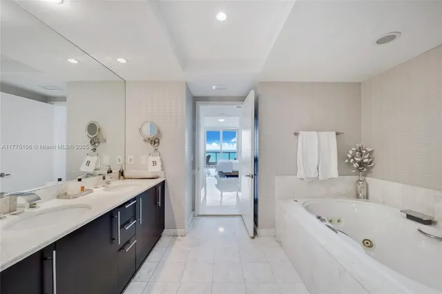 a large bathroom with a tub a sink shower and mirror