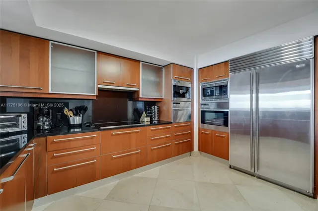 a kitchen with stainless steel appliances granite countertop a refrigerator and a stove top oven