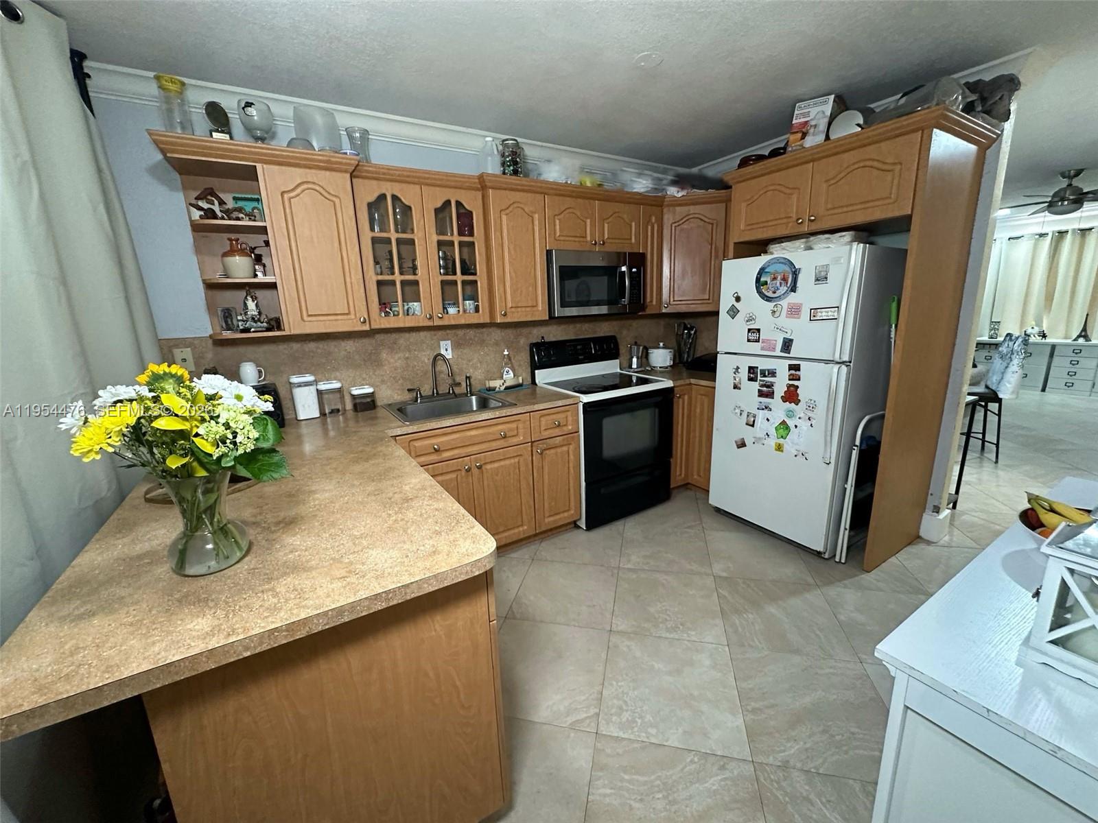 11537 Southwest 6th Street Sweetwater, FL 33174 - Photo 3 of 7 a kitchen with stainless steel appliances granite countertop a sink dishwasher stove and refrigerator