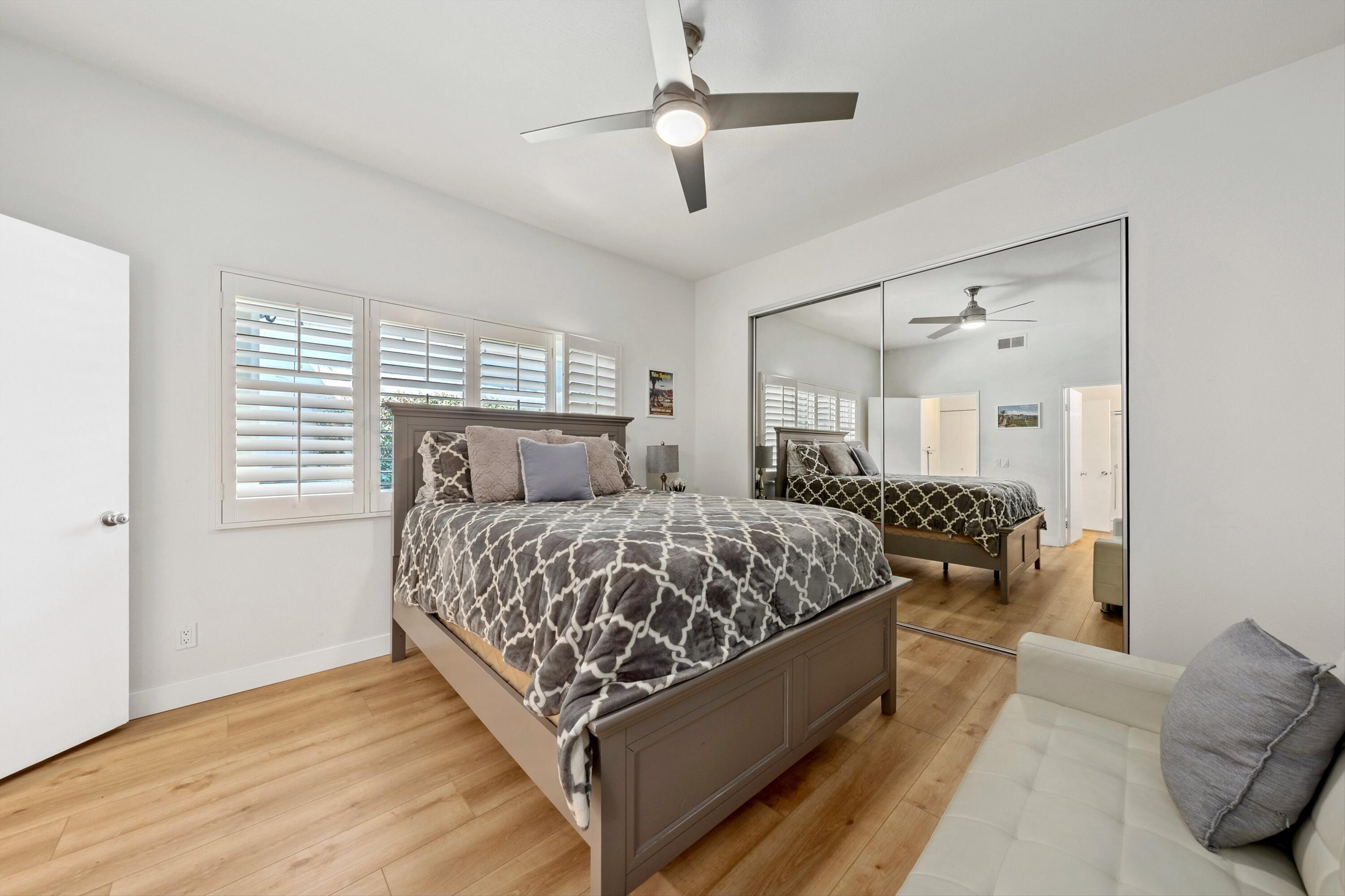 54326 Oak-Tree, Unit A122 La Quinta, CA 92253 - Photo 14 of 32 a bed room with a bed and a chandelier