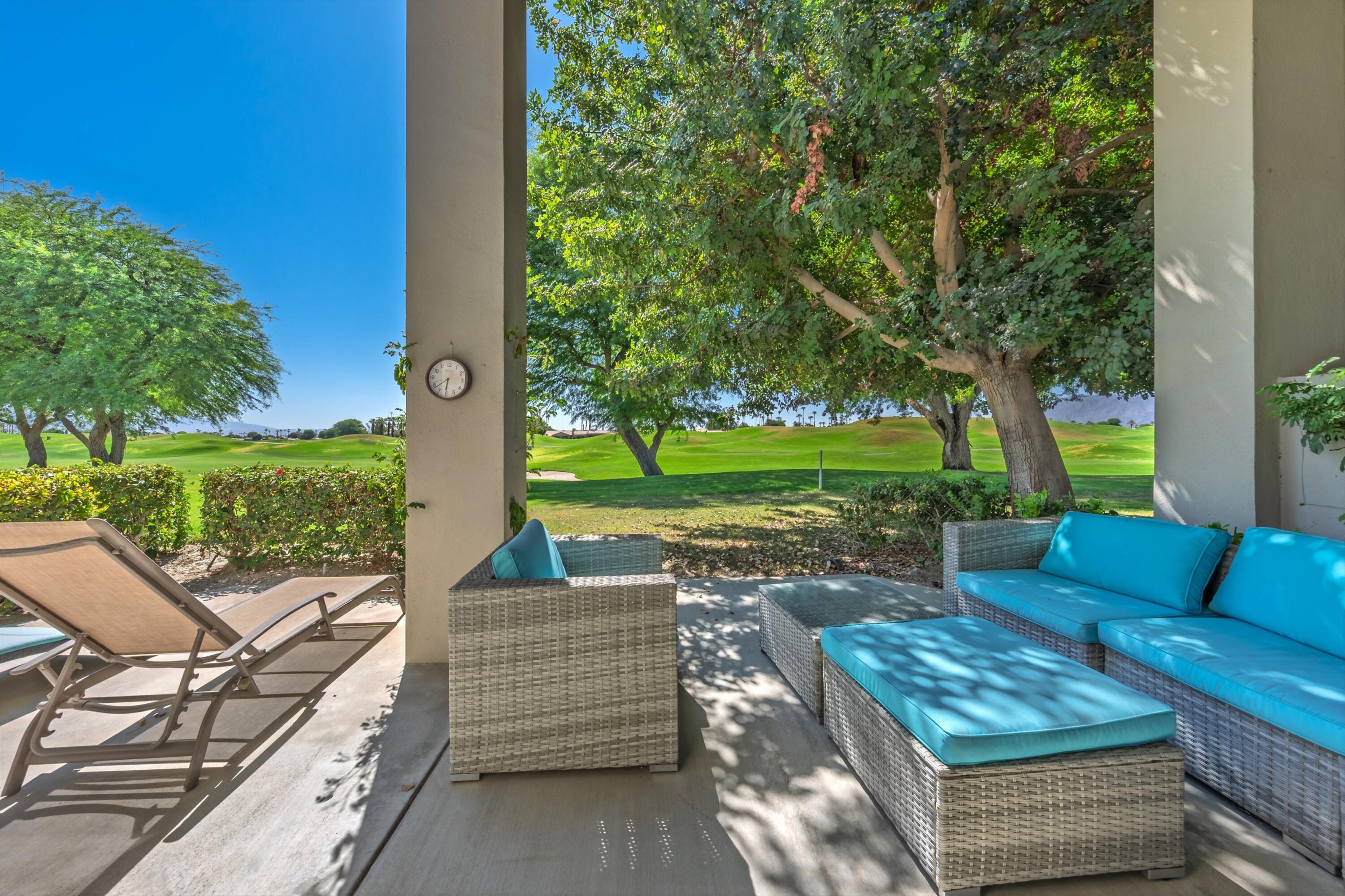 54326 Oak-Tree, Unit A122 La Quinta, CA 92253 - Photo 20 of 32 a view of a patio with couches potted plants and a big yard