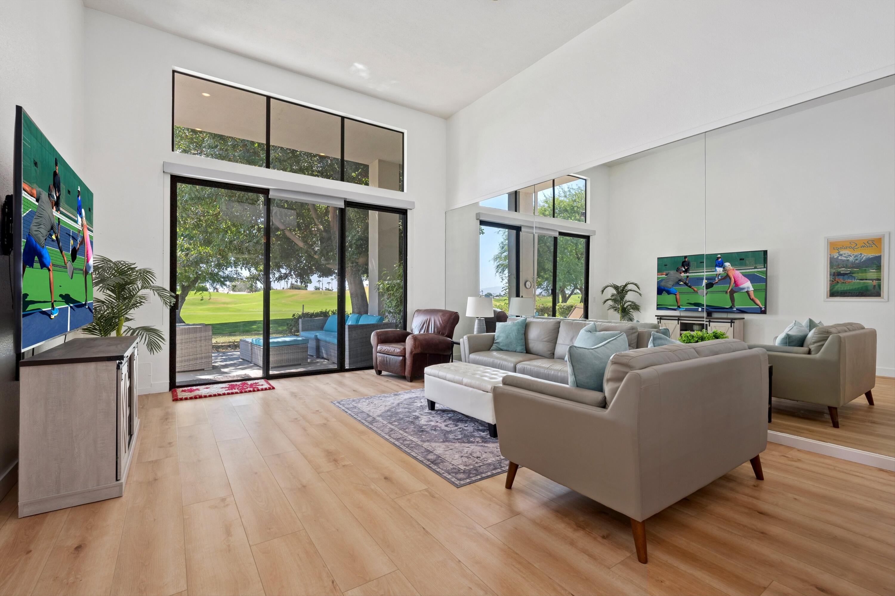 54326 Oak-Tree, Unit A122 La Quinta, CA 92253 - Photo 2 of 32 a living room with furniture large windows and wooden floor
