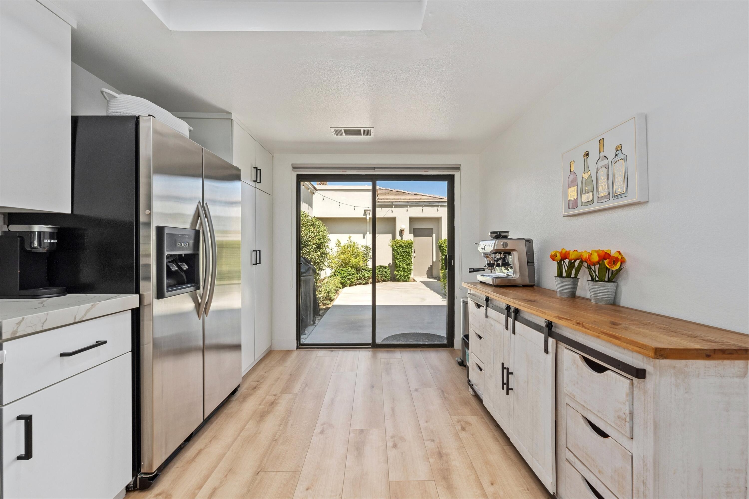 54326 Oak-Tree, Unit A122 La Quinta, CA 92253 - Photo 7 of 32 a kitchen with stainless steel appliances a refrigerator and wooden floor