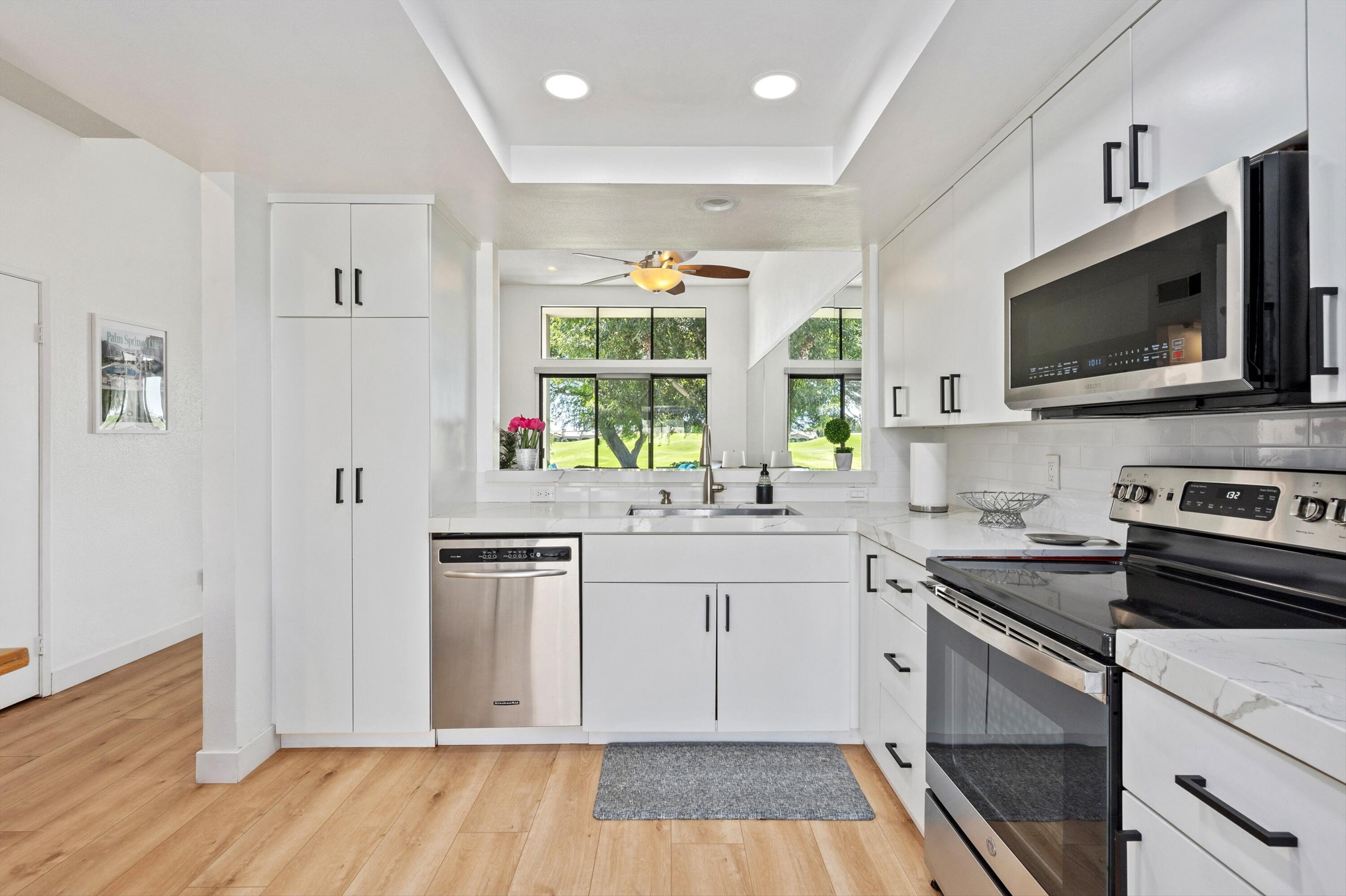 54326 Oak-Tree, Unit A122 La Quinta, CA 92253 - Photo 8 of 32 a kitchen with a sink stove and microwave
