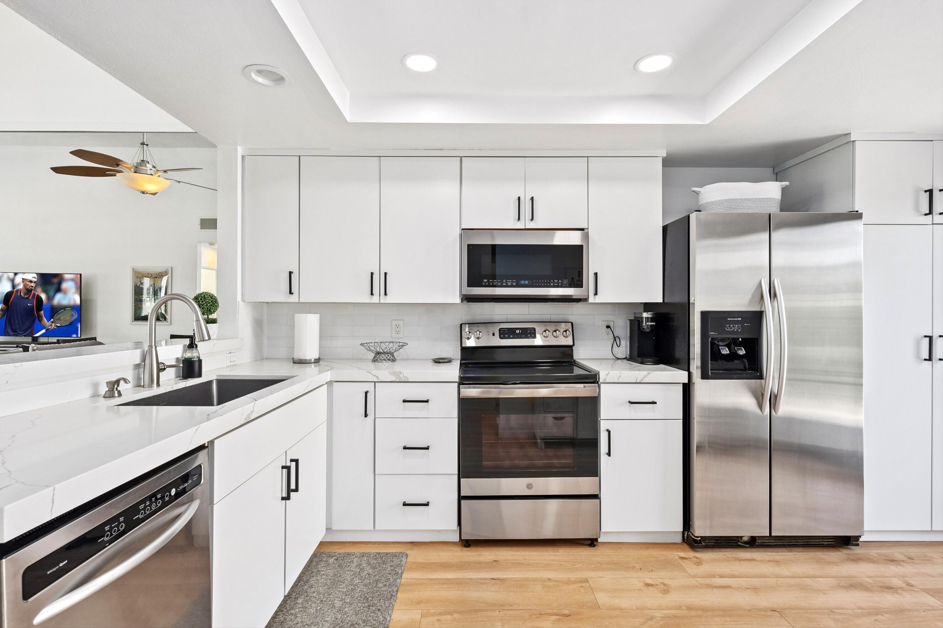 54326 Oak-Tree, Unit A122 La Quinta, CA 92253 - Photo 9 of 32 a kitchen with stainless steel appliances a sink cabinets and a refrigerator