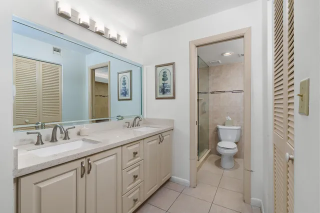 a bathroom with a granite countertop sink a toilet and a mirror