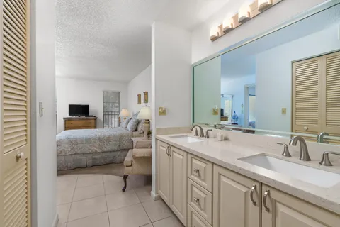 a en suite bathroom with a double vanity sink a mirror and a bathtub