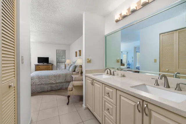 a en suite bathroom with a double vanity sink a mirror and a bathtub
