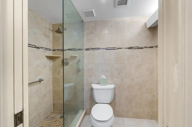 a bathroom with a toilet and a shower