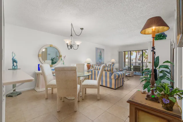 a living room with furniture a chandelier and a potted plant