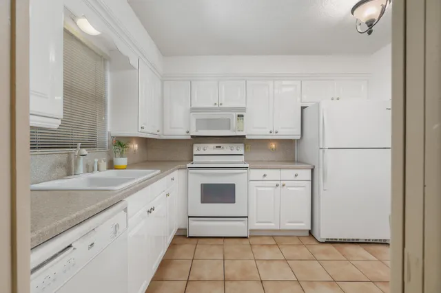 a kitchen with white cabinets appliances and a sink