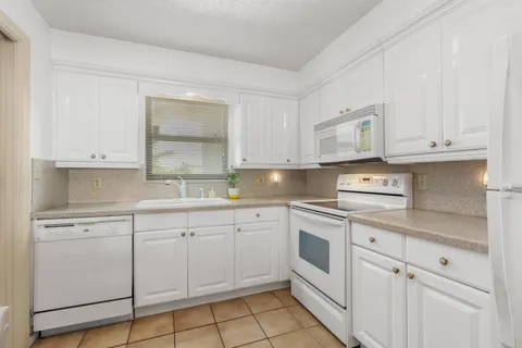 a kitchen with white cabinets stainless steel appliances and a sink