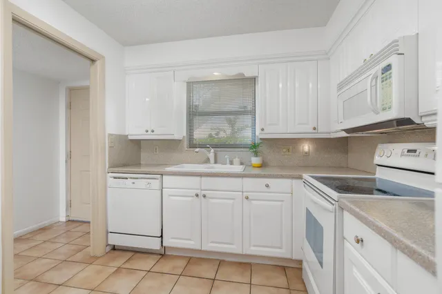 a kitchen with cabinets appliances a sink and a counter top space