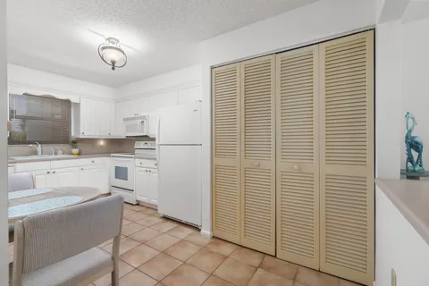 a kitchen with white cabinets and white appliances