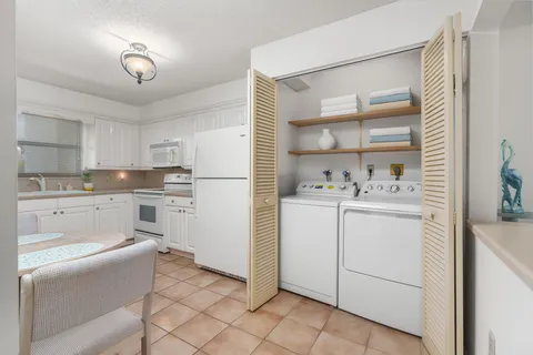 a kitchen with white cabinets and white appliances