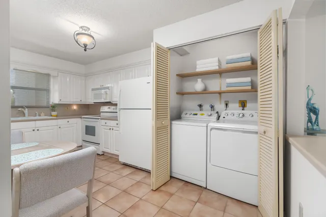 a kitchen with white cabinets and white appliances