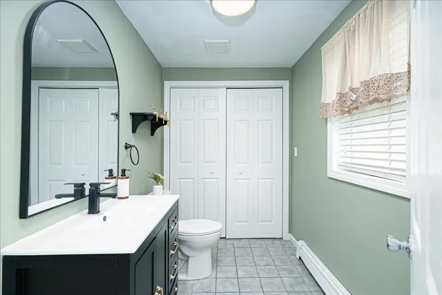 a bathroom with a sink a toilet and a mirror