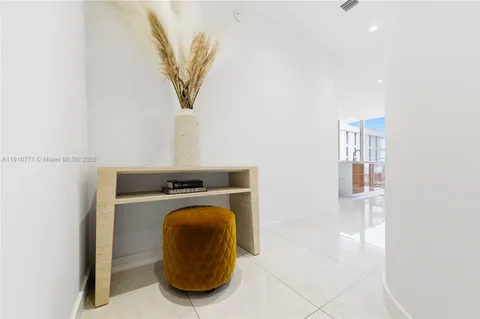 a living room with furniture a flat screen tv and a view of kitchen