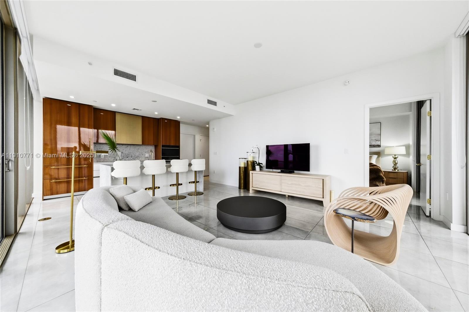 2678 Tigertail Avenue, Unit 1110 Miami, FL 33133 - Photo 40 of 77 a living room with furniture a flat screen tv and a view of kitchen