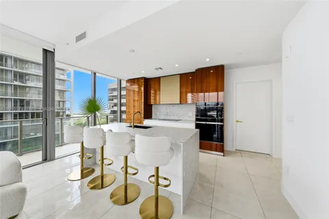 a large living room with stainless steel appliances kitchen island granite countertop furniture a sink and a large mirror