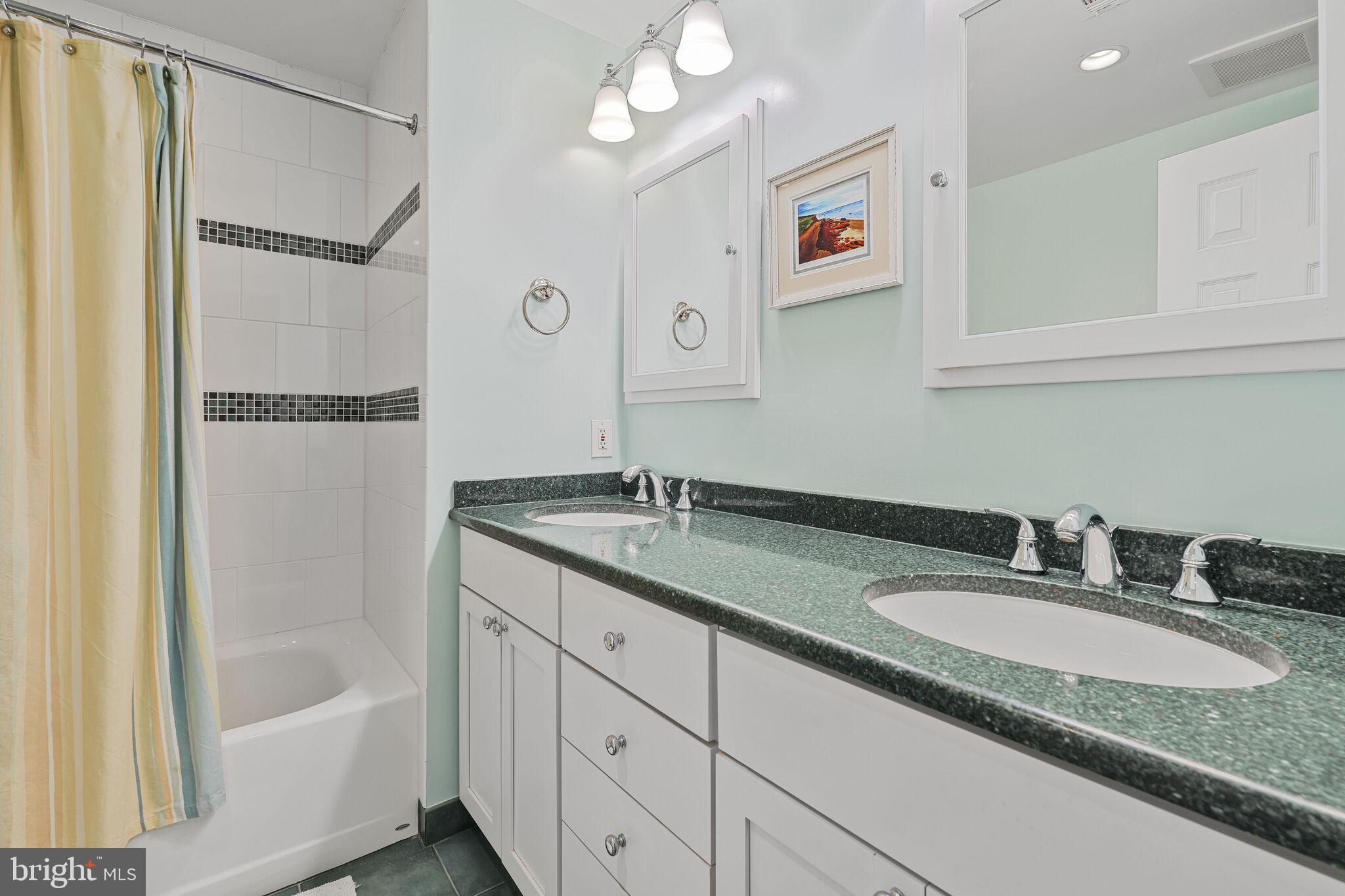 9501 Columbia Boulevard Silver Spring, MD 20910 - Photo 25 of 32 a bathroom with a granite countertop sink mirror and a bathtub