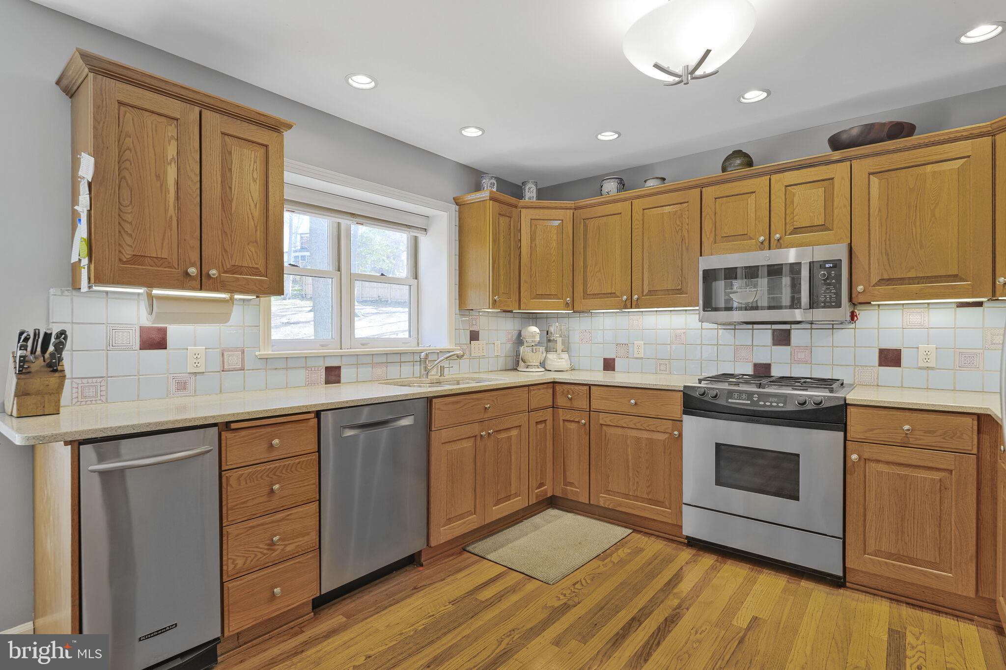 9501 Columbia Boulevard Silver Spring, MD 20910 - Photo 8 of 32 a kitchen with granite countertop wooden cabinets stainless steel appliances a sink and a window