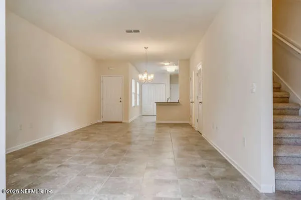 an empty room with chandelier and windows