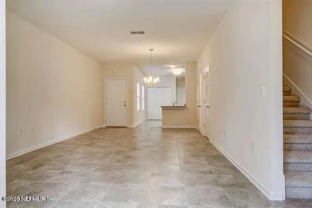 an empty room with chandelier and windows