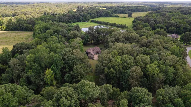 an aerial view of residential houses with outdoor space and trees