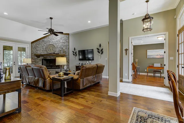 a living room with furniture a fireplace and a chandelier