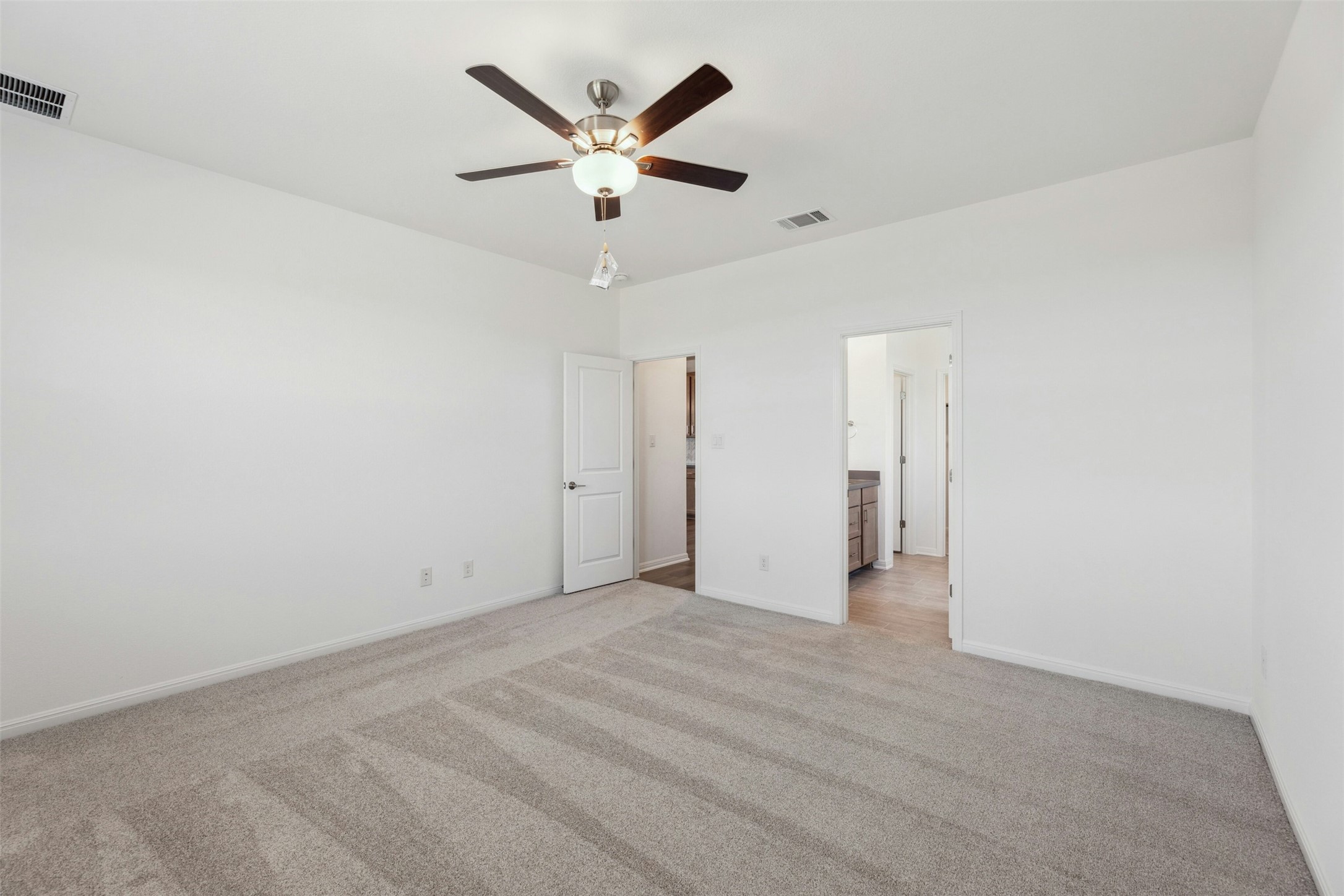 2001 Wynn Road Hutto, TX 78634 - Photo 14 of 39 An airy bedroom with soft carpeting awaits, offering a peaceful retreat with a connected private bath.