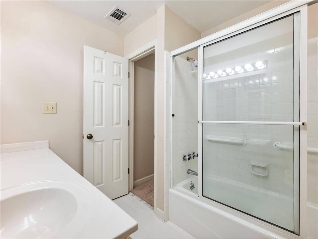 2235 Old Hamilton Place, Unit 100B Gainesville, GA 30507 - Photo 20 of 31 a bathroom with a glass shower door and a mirror