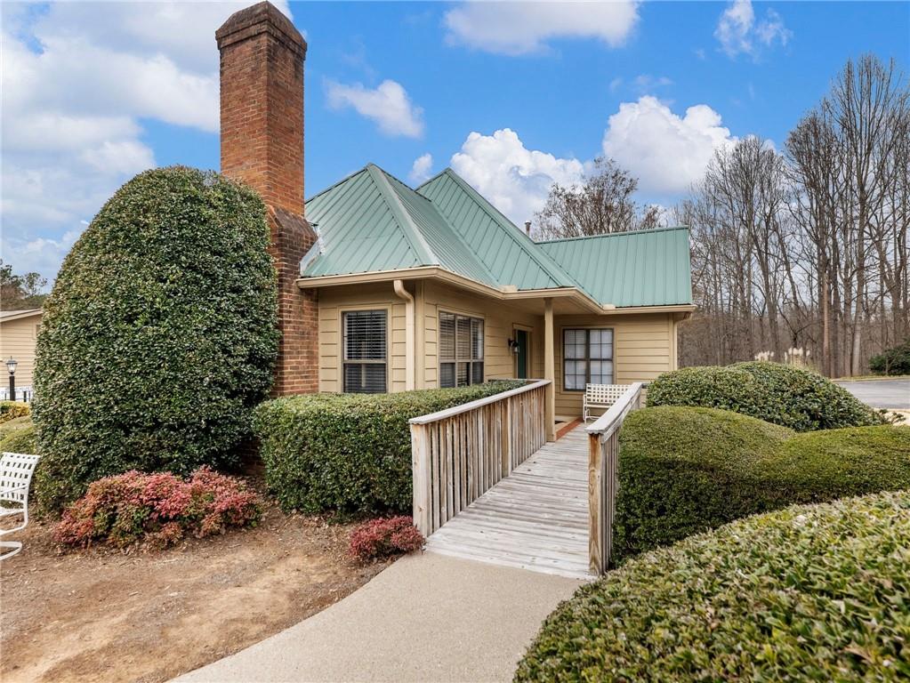 2235 Old Hamilton Place, Unit 100B Gainesville, GA 30507 - Photo 4 of 31 a front view of a house with a garden and trees